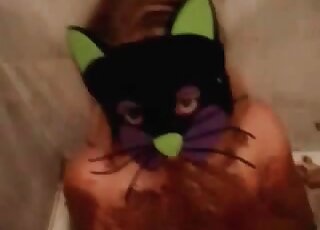 Wearing a kitty mask and playing with lots of poop