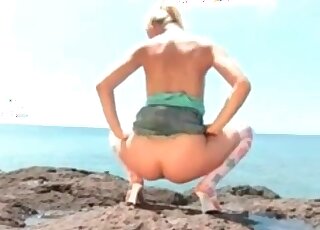 Seaside solo shit action with one leggy blonde bitch